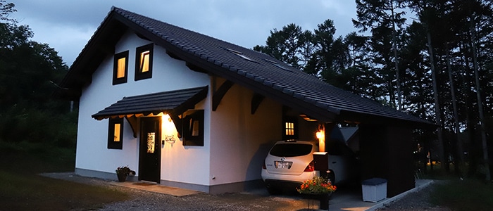 夕暮れの家に明かりがともっている画像