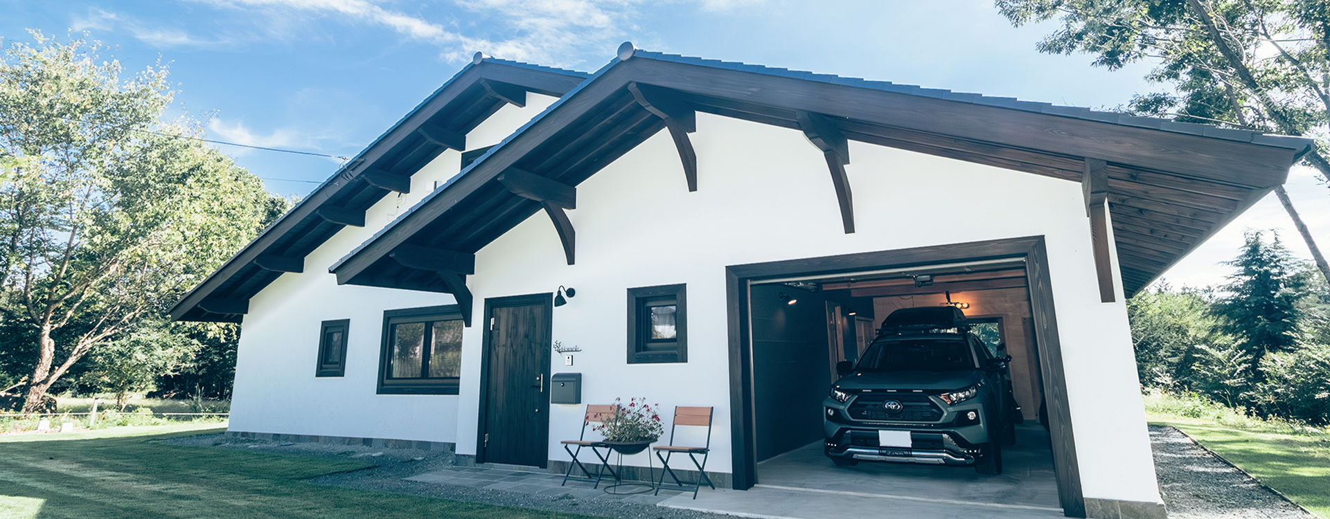 ガレージに車が停まる白い外壁の住宅の外観